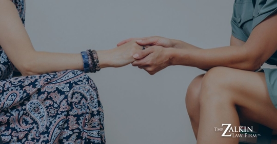 woman holding the hands of another woman in show of support