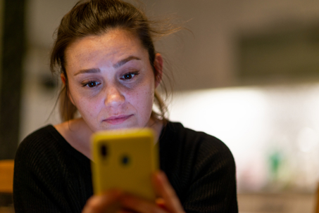 Woman looking on her phone for answers as she wants to take action about the childhood abuse she experienced.